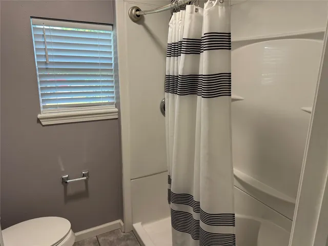 a bathroom with a shower toilet and sink