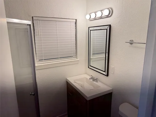 a bathroom with a sink a toilet and mirror