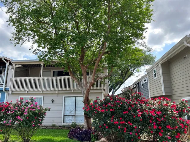 a front view of house and yard with beautiful flowers