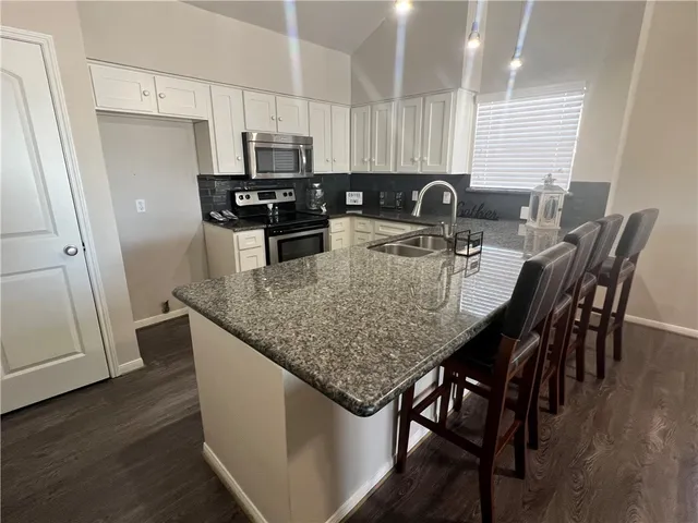 a view of a bedroom with wooden floor and a ceiling fan
