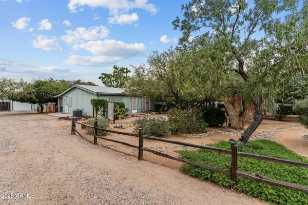a view of house with backyard and sitting area