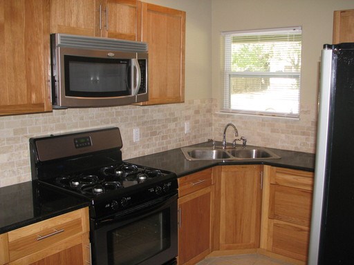 907 West 30th Street, Unit B Austin, TX 78705 - Photo 17 of 20 a kitchen with granite countertop a stove sink and microwave
