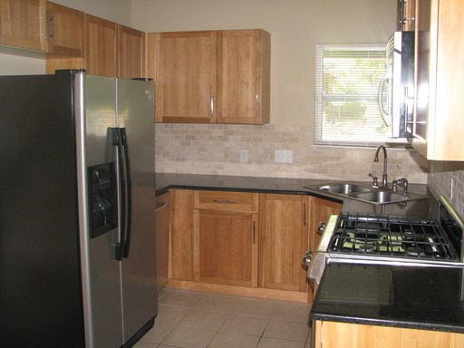 907 West 30th Street, Unit B Austin, TX 78705 - Photo 3 of 20 a kitchen with stainless steel appliances granite countertop a refrigerator and a sink