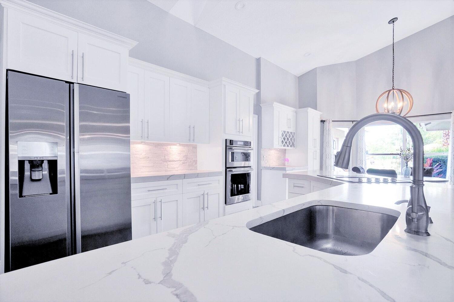 a kitchen with a refrigerator sink and cabinets