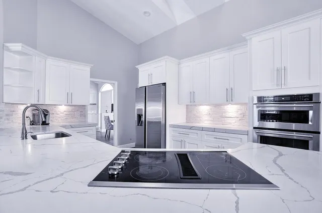 a kitchen with a sink stove cabinets and wooden floor