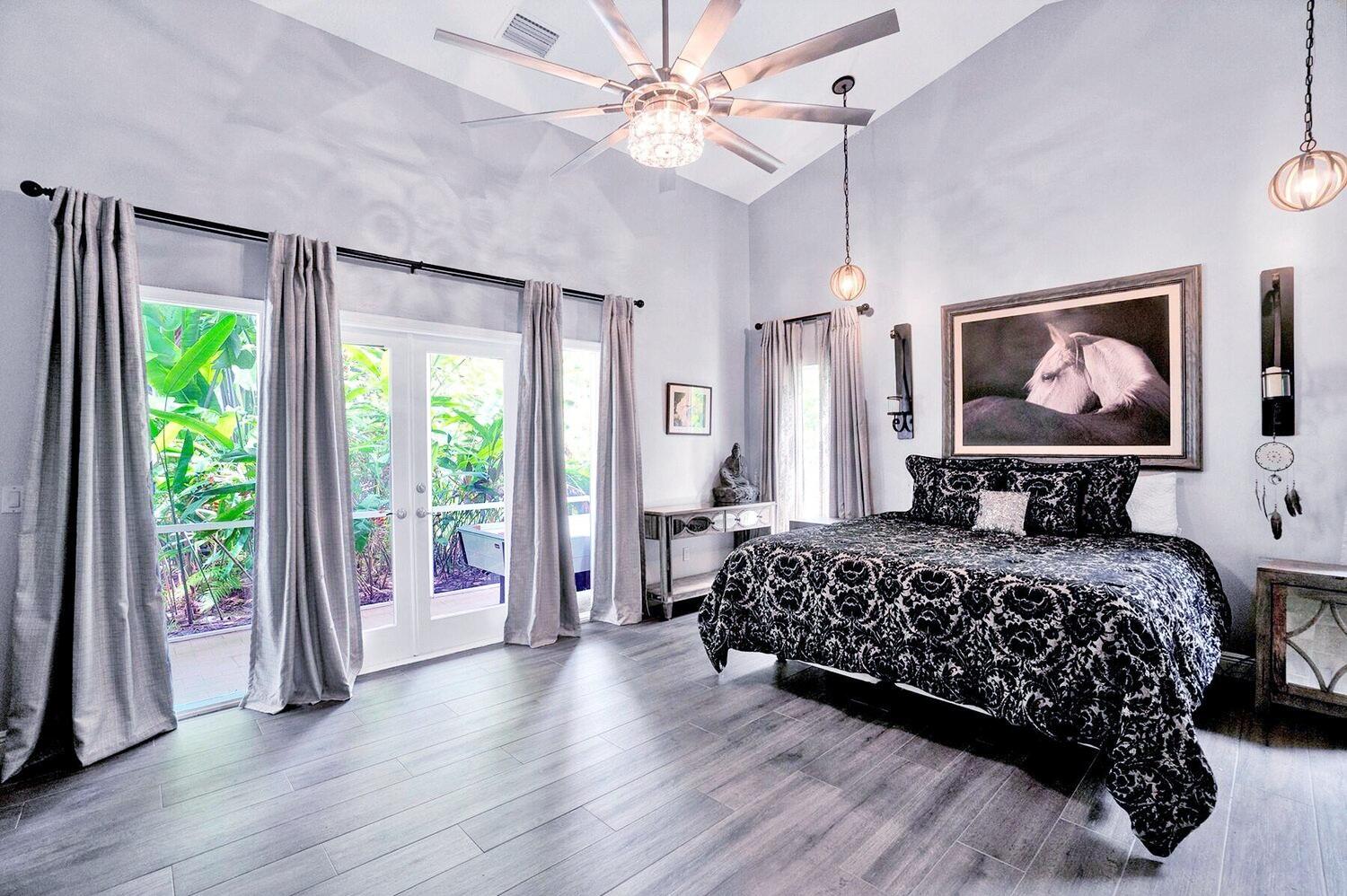 1350 Longlea Terrace Wellington, FL 33414 - Photo 10 of 61 a bedroom with a large bed and a chandelier