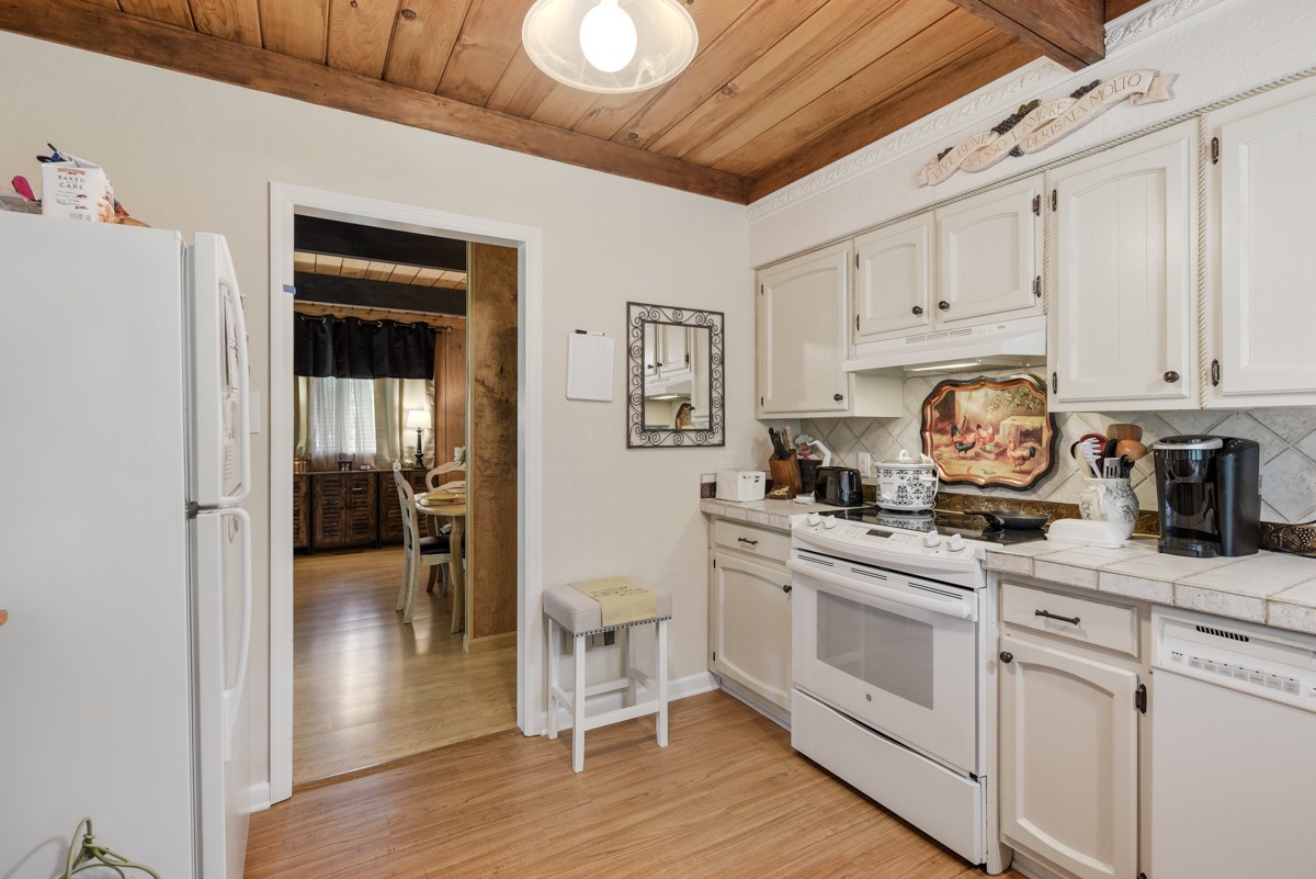 205 Allen Road Goodlettsville, TN 37072 - Photo 20 of 43 a kitchen with granite countertop a stove top oven a sink a dining table and chairs with wooden floor