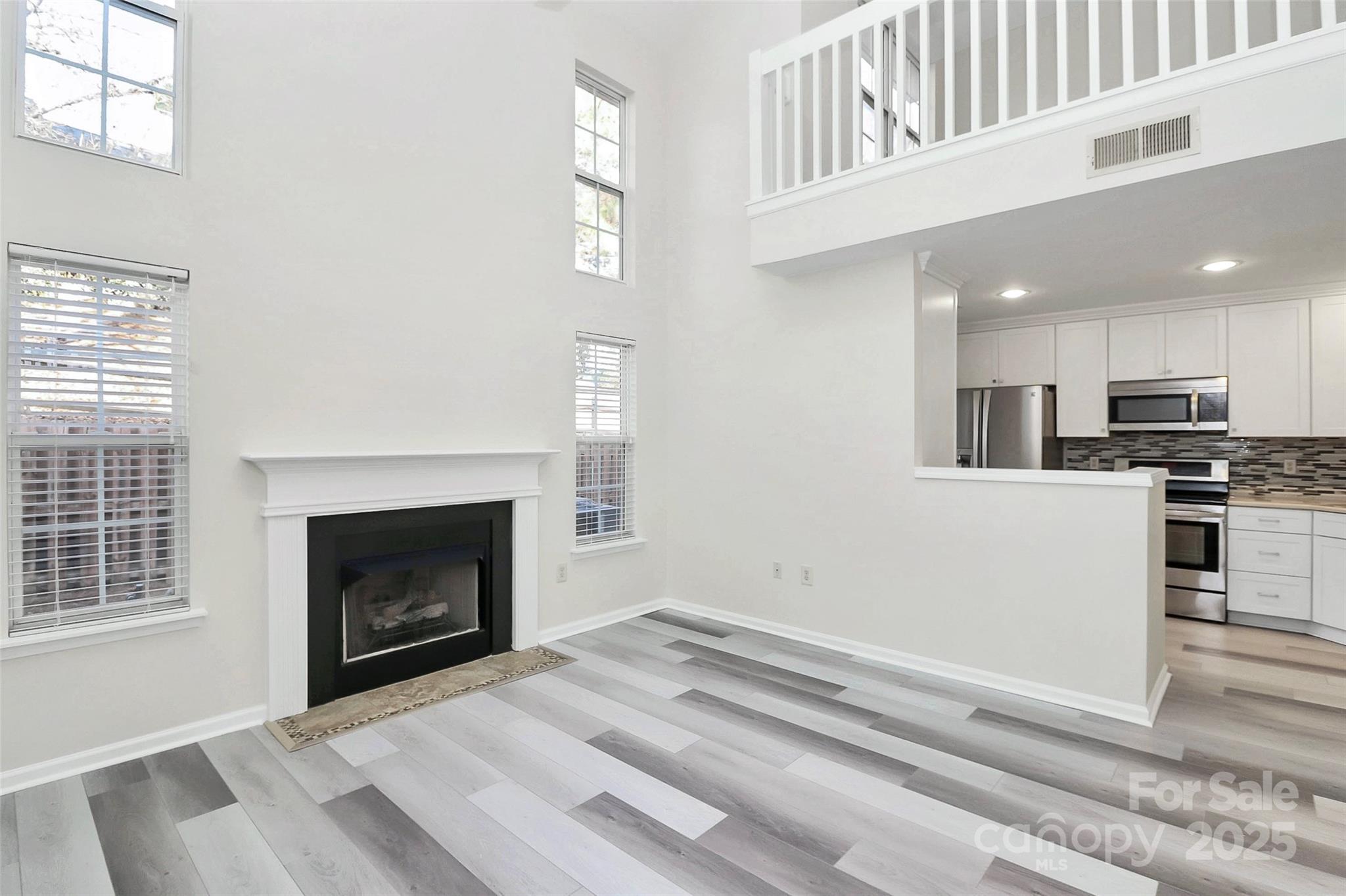 441 Robin Reed Court Pineville, NC 28134 - Photo 13 of 33 a view of kitchen and empty room with wooden floor
