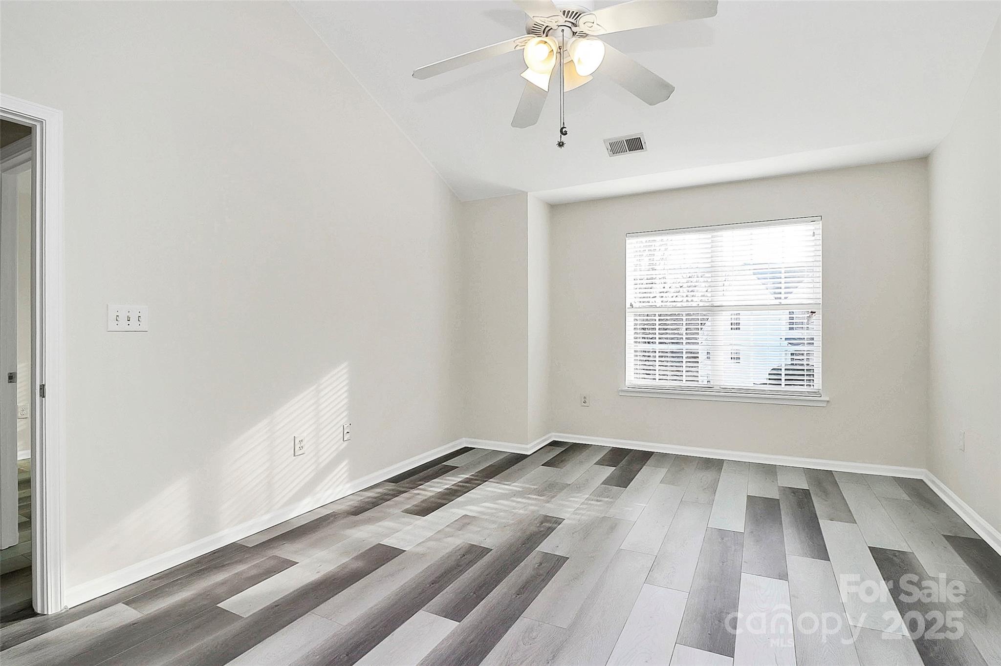 441 Robin Reed Court Pineville, NC 28134 - Photo 22 of 33 an empty room with wooden floor fan and windows