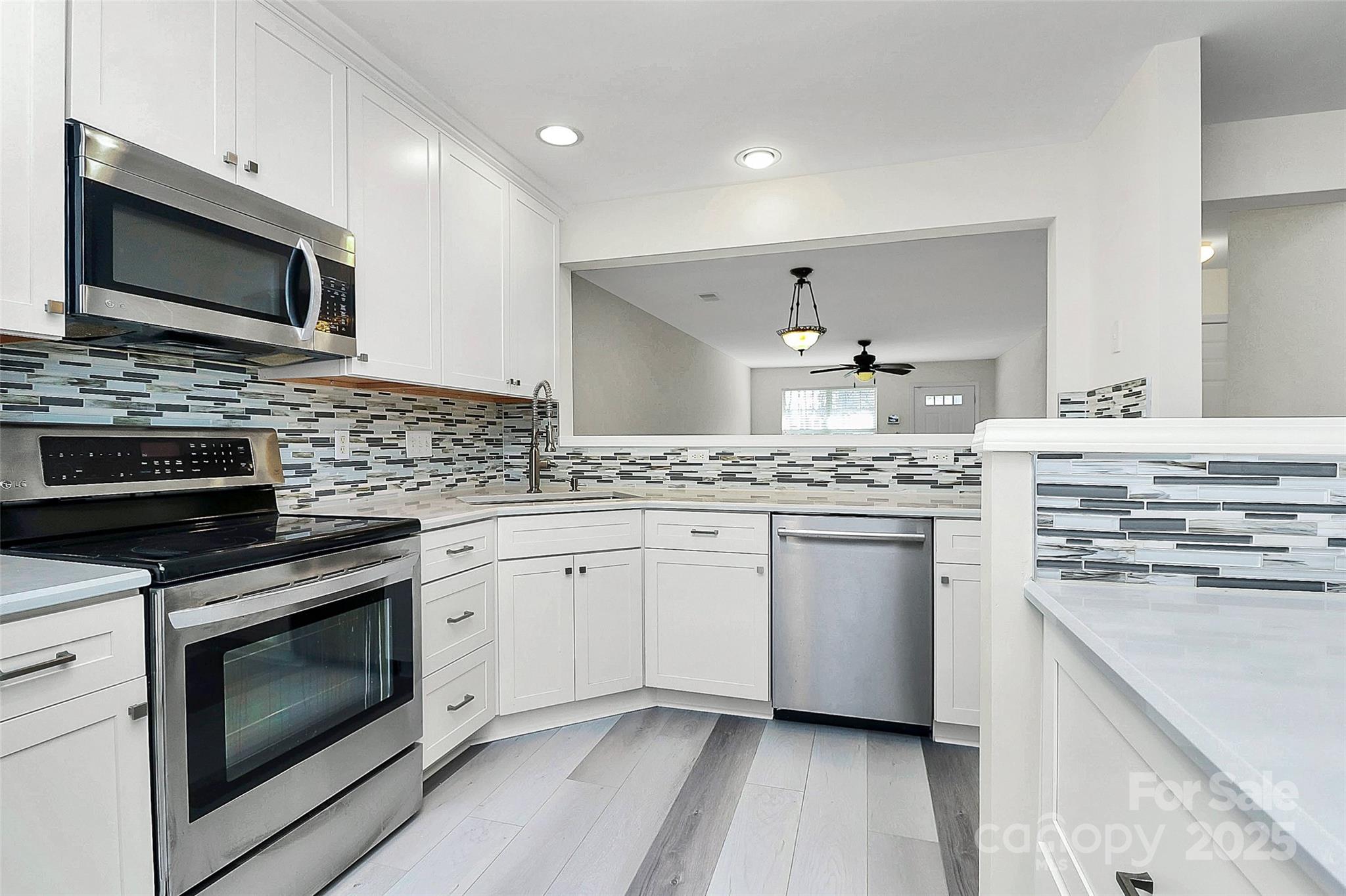 441 Robin Reed Court Pineville, NC 28134 - Photo 4 of 33 a kitchen with stainless steel appliances granite countertop a stove top oven a sink dishwasher and a microwave oven with wooden floor
