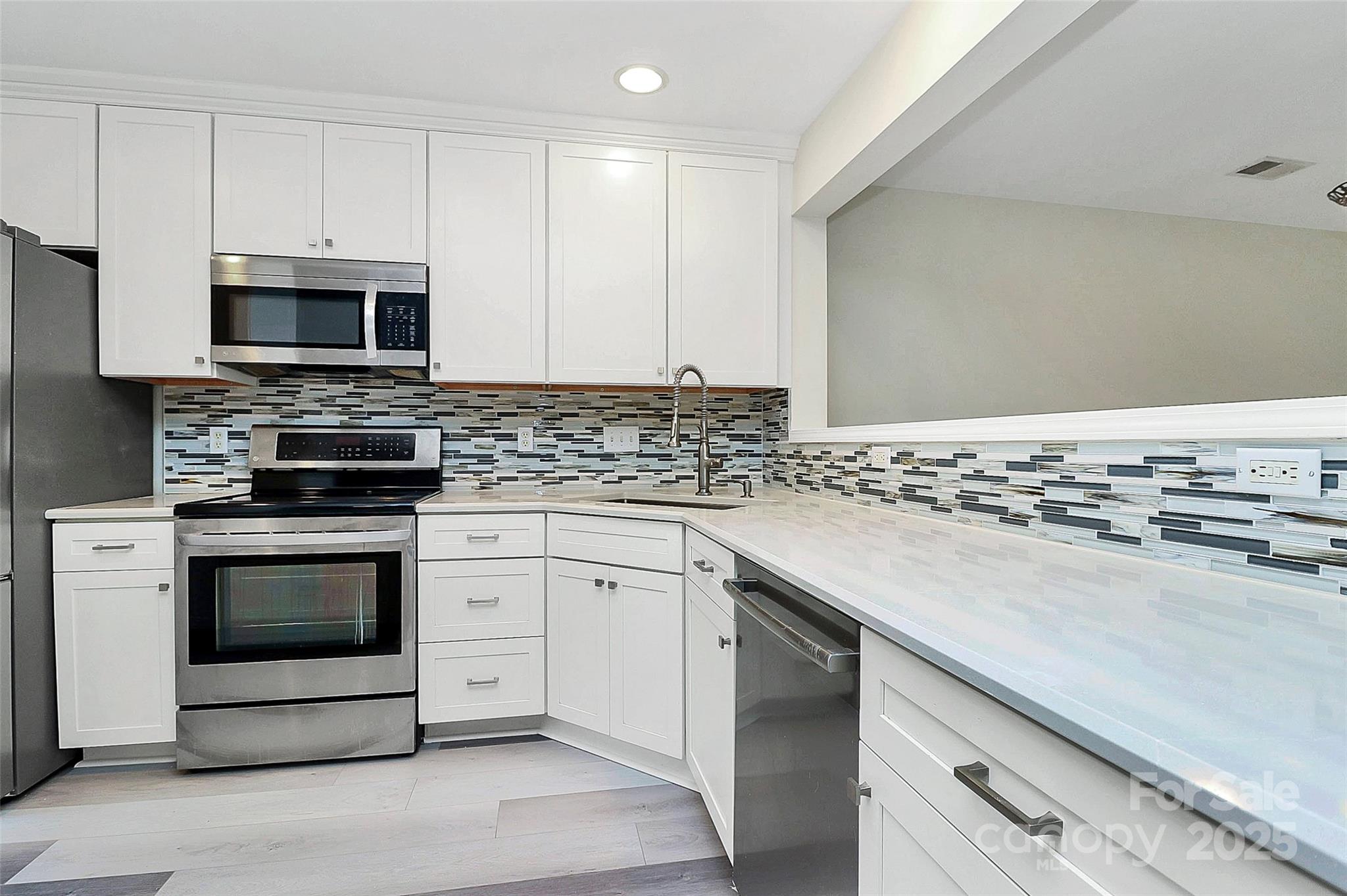 441 Robin Reed Court Pineville, NC 28134 - Photo 5 of 33 a kitchen with stainless steel appliances granite countertop a stove a sink and a microwave