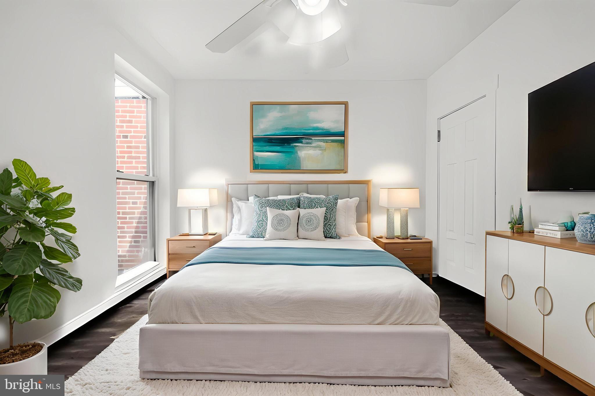 7734 Temple Road Philadelphia, PA 19150 - Photo 15 of 33 a bedroom with a large bed and a flat screen tv