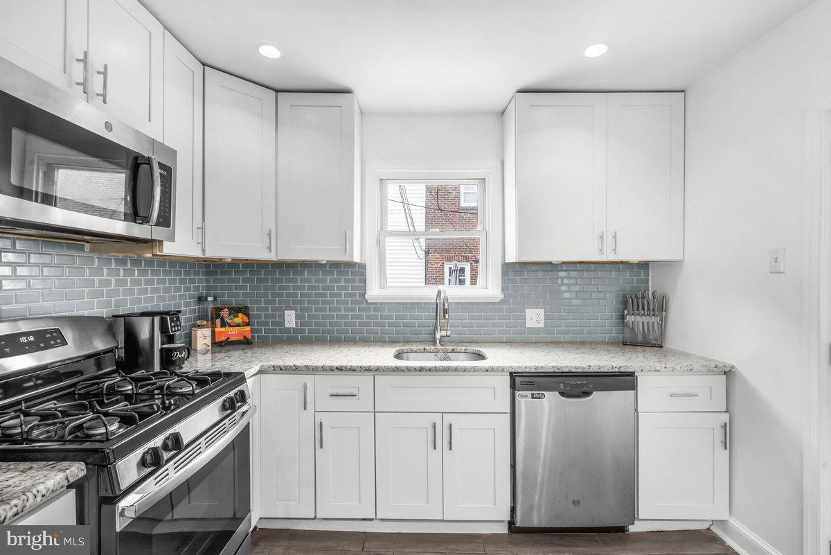 7734 Temple Road Philadelphia, PA 19150 - Photo 6 of 33 a kitchen with stainless steel appliances granite countertop a sink stove and cabinets