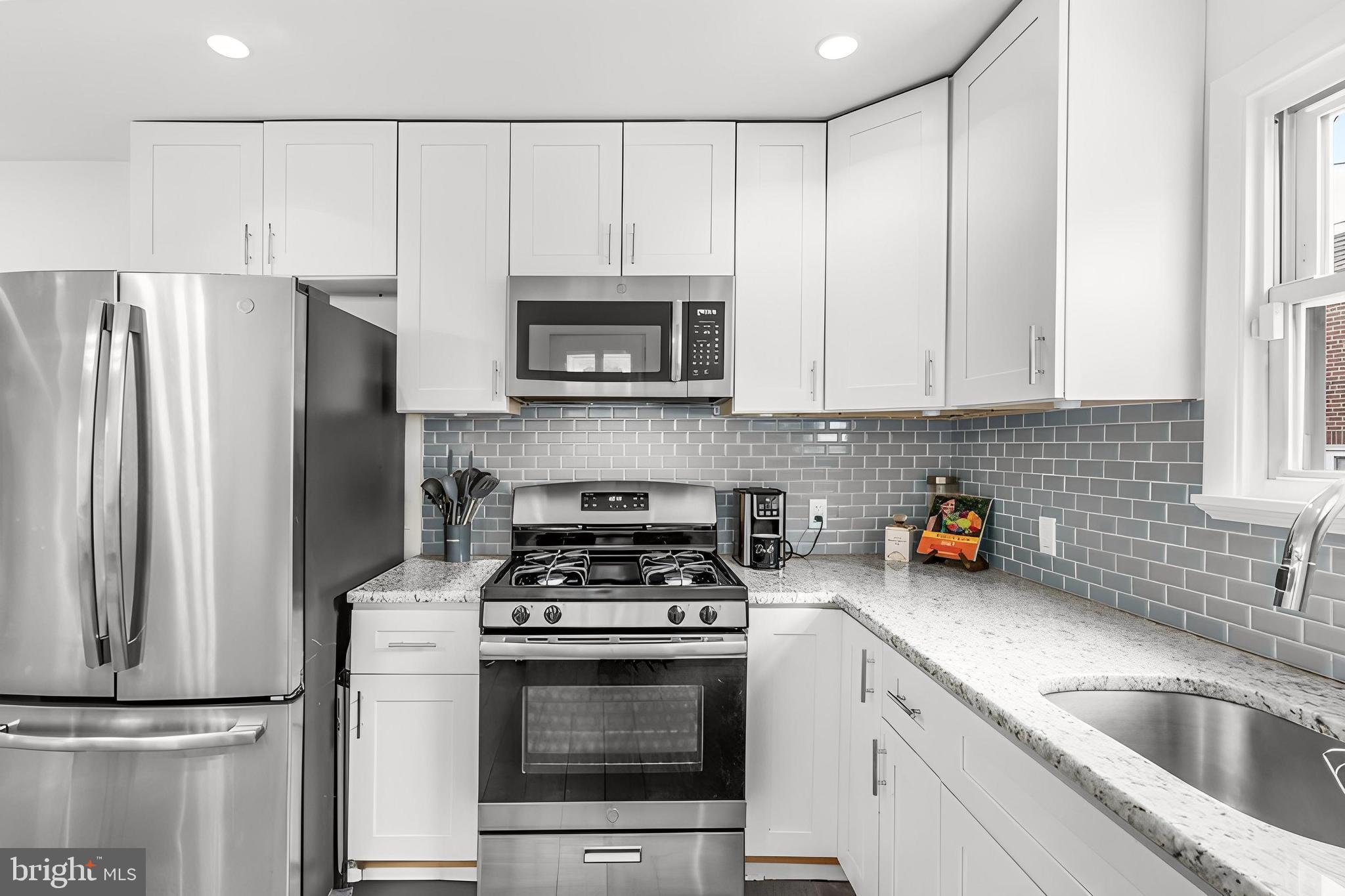 7734 Temple Road Philadelphia, PA 19150 - Photo 7 of 33 a kitchen with cabinets stainless steel appliances a sink and a counter top space