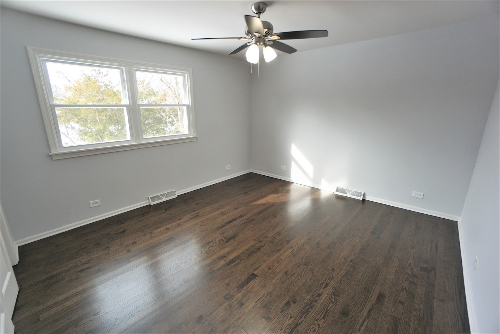 2842 Scott Crescent Flossmoor, IL 60422 - Photo 19 of 43 an empty room with wooden floor chandelier fan and windows
