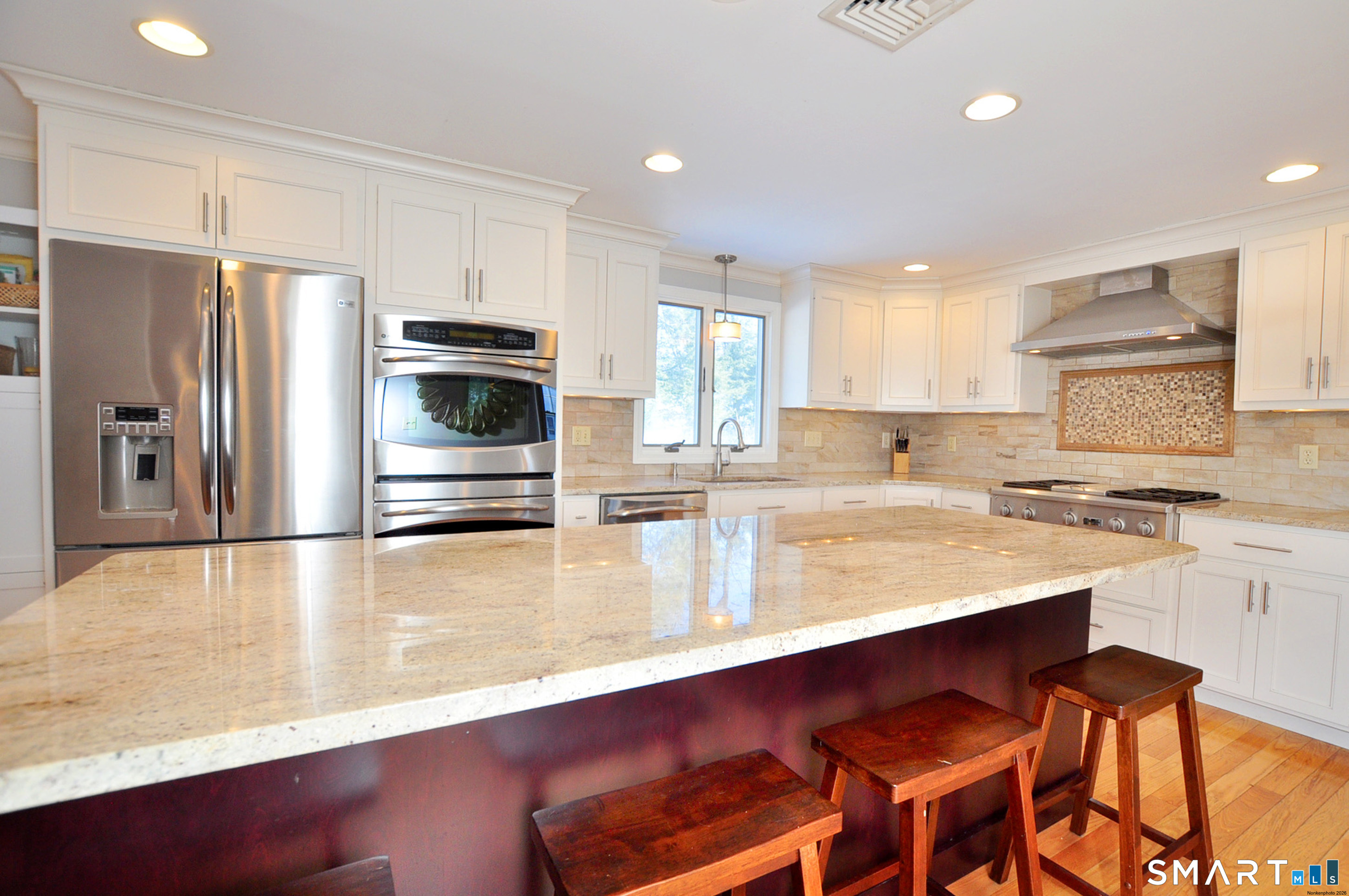 90 Seminary Road Simsbury, CT 06070 - Photo 27 of 34 a kitchen with stainless steel appliances a sink a stove a refrigerator with white cabinets and wooden floor
