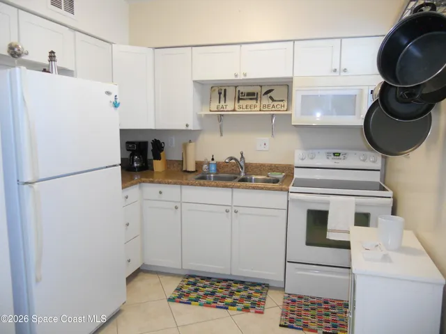 a kitchen with stainless steel appliances granite countertop a sink a stove and white cabinets