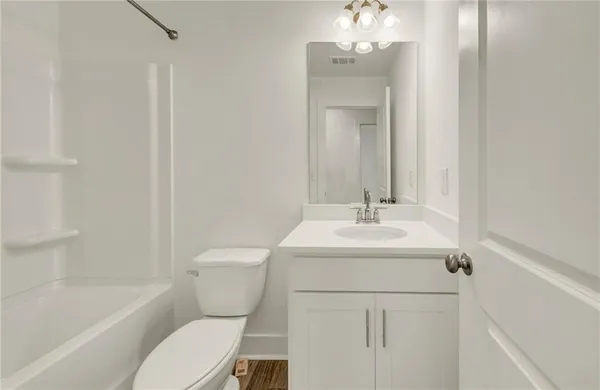 a bathroom with a sink toilet vanity and tub