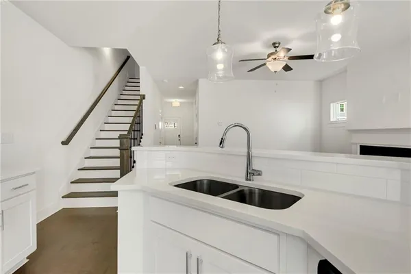 a kitchen with stainless steel appliances a sink a stove and chairs