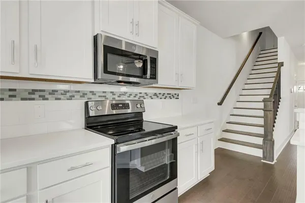 a kitchen with white cabinets and appliances