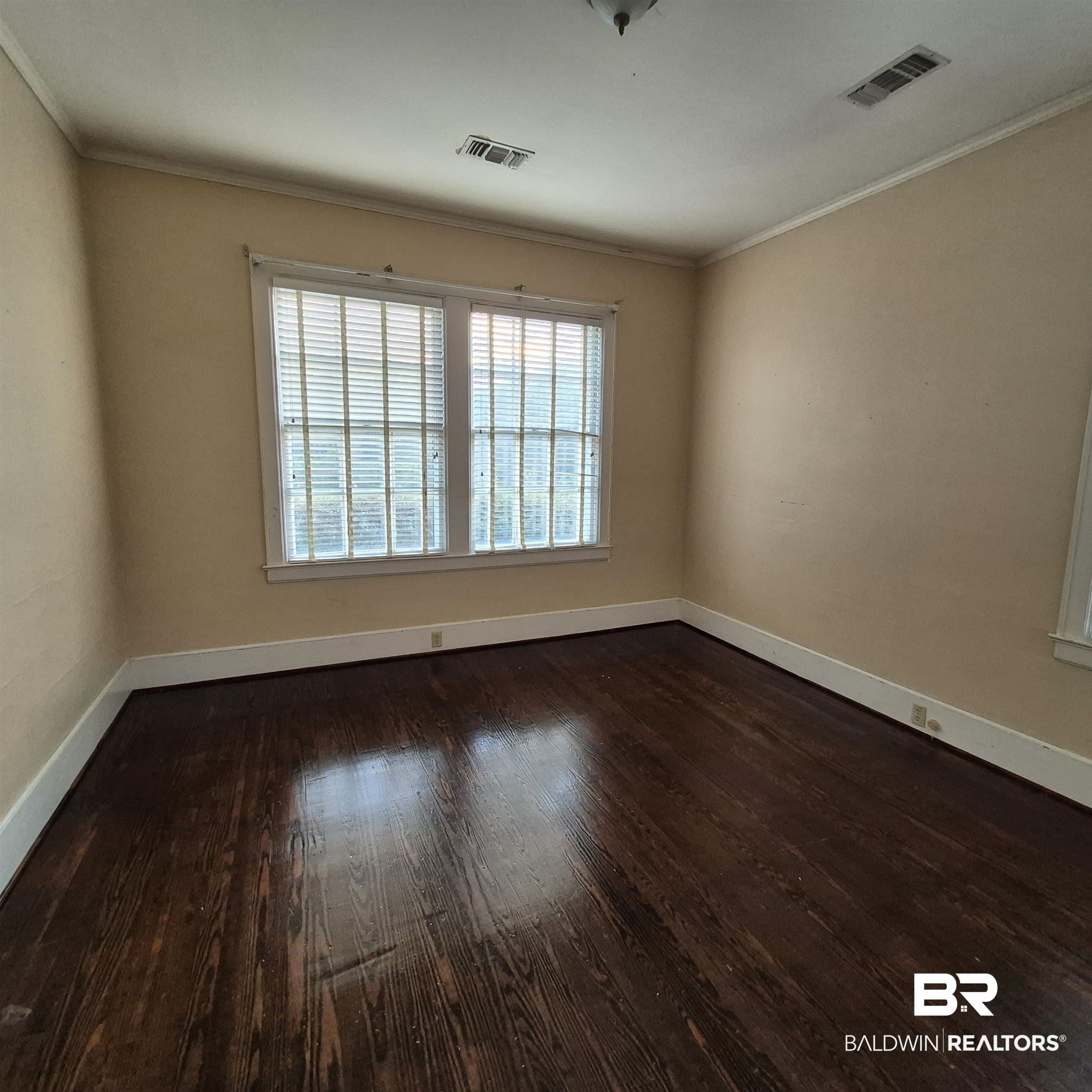 308 Rural Street Evergreen, AL 36401 - Photo 11 of 40 Unfurnished room featuring dark wood-style floors and crown molding