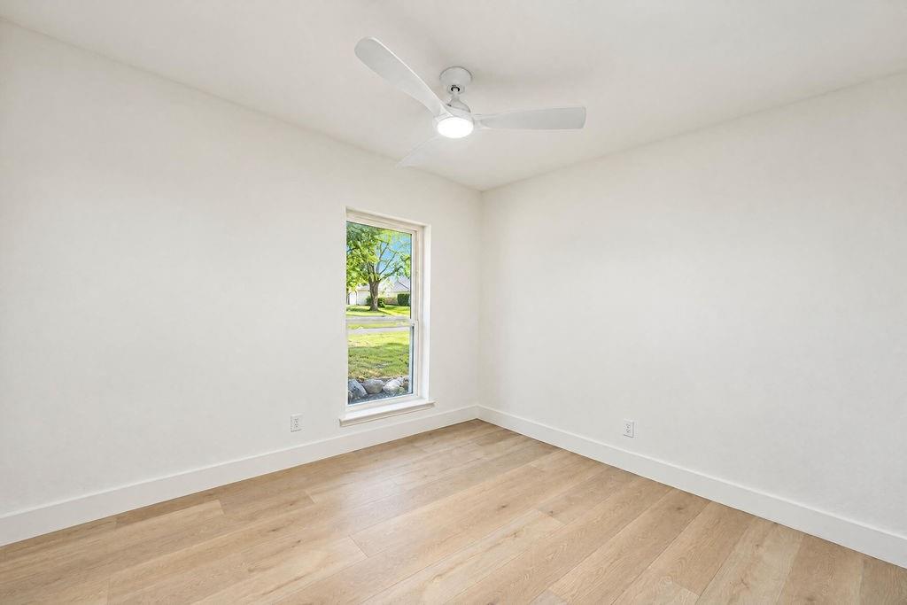 1904 Apollo Road Richardson, TX 75081 - Photo 29 of 40 Light wood-finish flooring, white walls, and a ceiling-mounted fan with integrated lighting