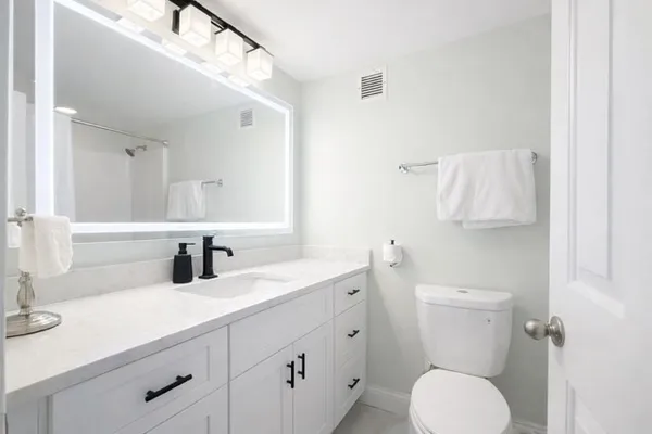 a bathroom with a toilet sink and mirror
