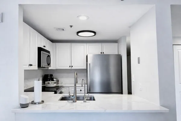 a kitchen with stainless steel appliances granite countertop a refrigerator and a sink