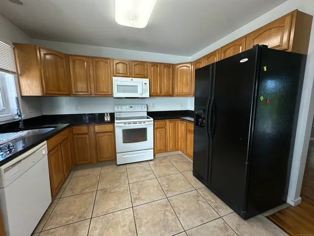 a kitchen with stainless steel appliances granite countertop a refrigerator a sink and a stove