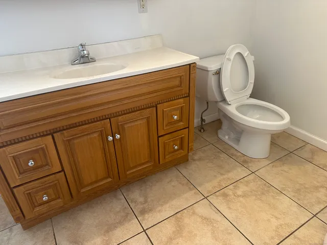 a spacious bathroom with a toilet sink and mirror