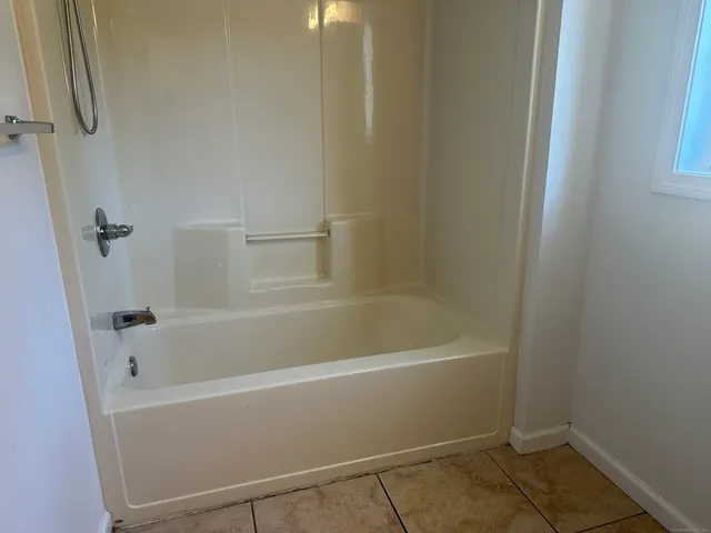 a white bath tub and a shower