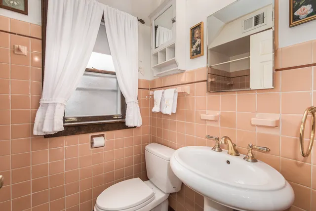 a bathroom with a toilet sink and mirror
