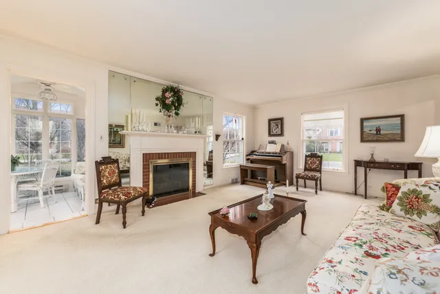 a living room with furniture a fireplace and a table with kitchen view