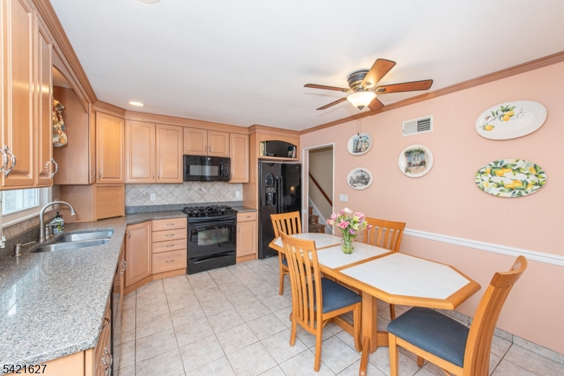 4 Oak Ridge North Caldwell, NJ 07006 - Photo 9 of 33 a kitchen with stainless steel appliances granite countertop a stove top oven a sink a dining table and chairs