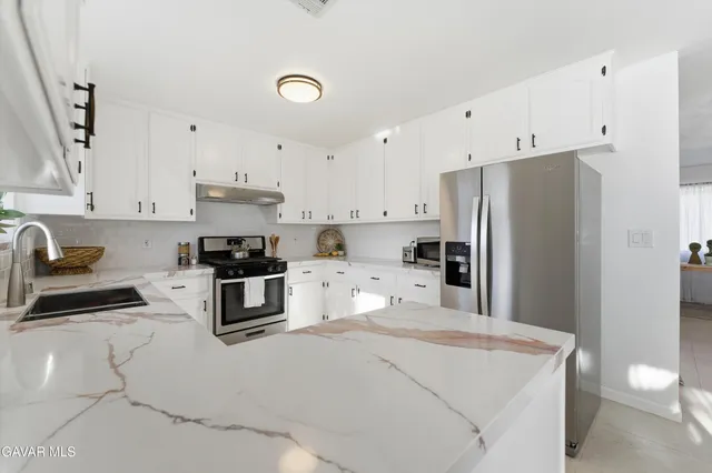 a kitchen with stainless steel appliances a refrigerator stove microwave and sink