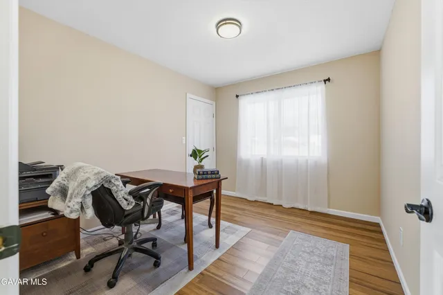 a view of a workspace with furniture and a window