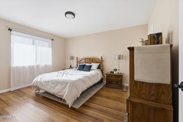 a bedroom with a bed and wooden floor