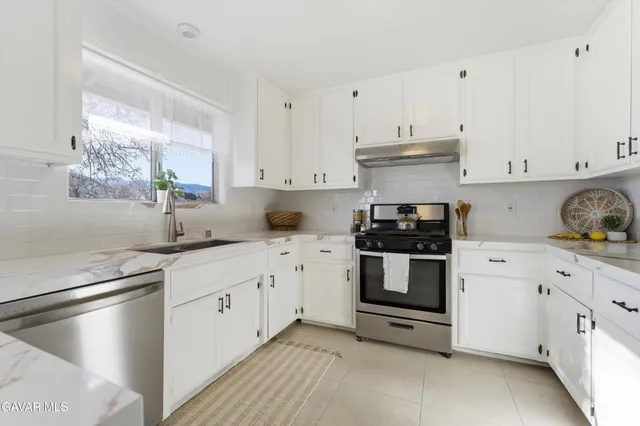 a kitchen with granite countertop white cabinets and white appliances