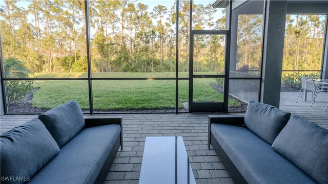a living room with furniture and a floor to ceiling window