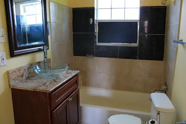 a bathroom with a granite countertop sink toilet and shower