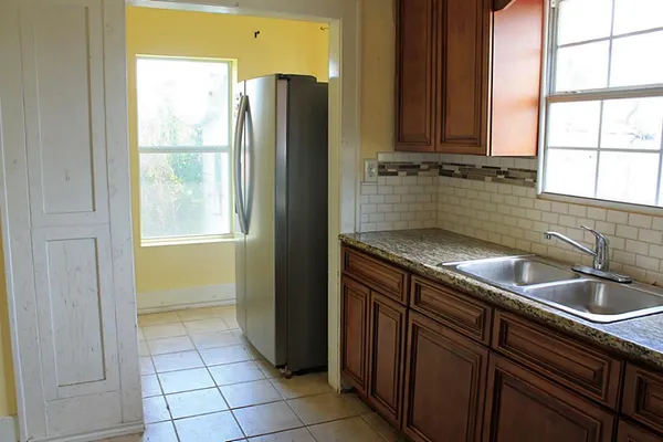 a kitchen with a sink window and cabinets