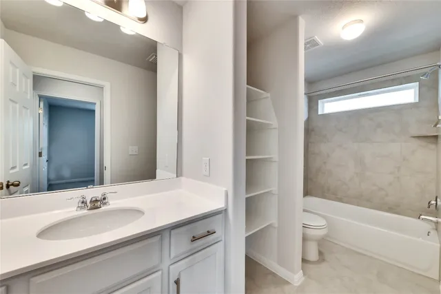 a bathroom with a sink a toilet and a large mirror
