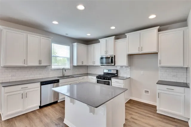 a kitchen with granite countertop white cabinets and white appliances