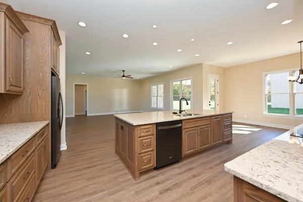 a large kitchen with stainless steel appliances granite countertop a lot of counter space and wooden floor