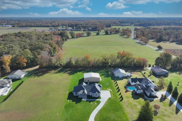 aerial view of a house with garden space and lake view in back