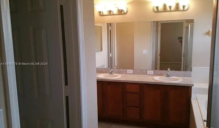 3665 Barred Owl Road Lakeland, FL 33811 - Photo 5 of 7 a bathroom with double sink and a mirror