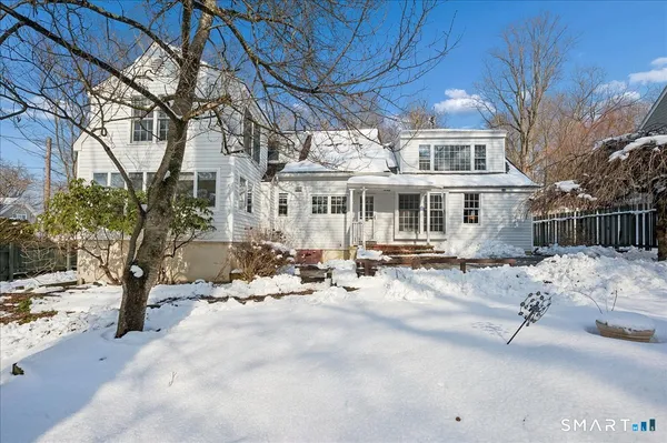 a view of a house with a yard covered in snow