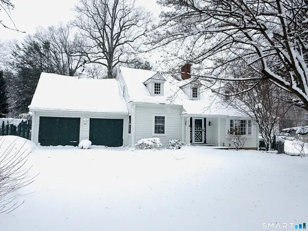 a front view of house with yard covered in snow