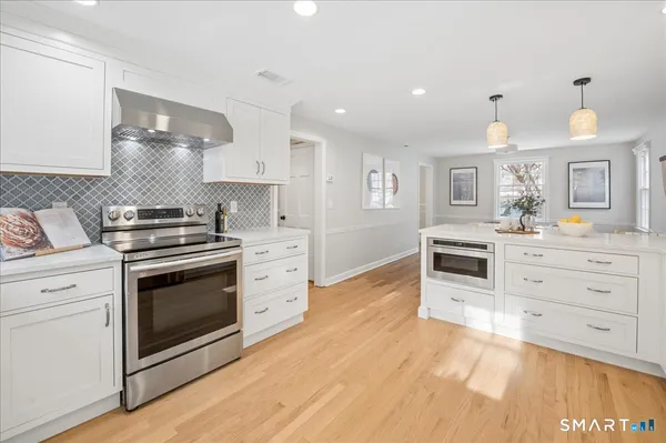 a kitchen with granite countertop a stove top oven and cabinets