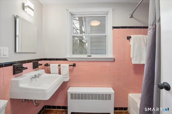 a bathroom with a sink and mirror with window